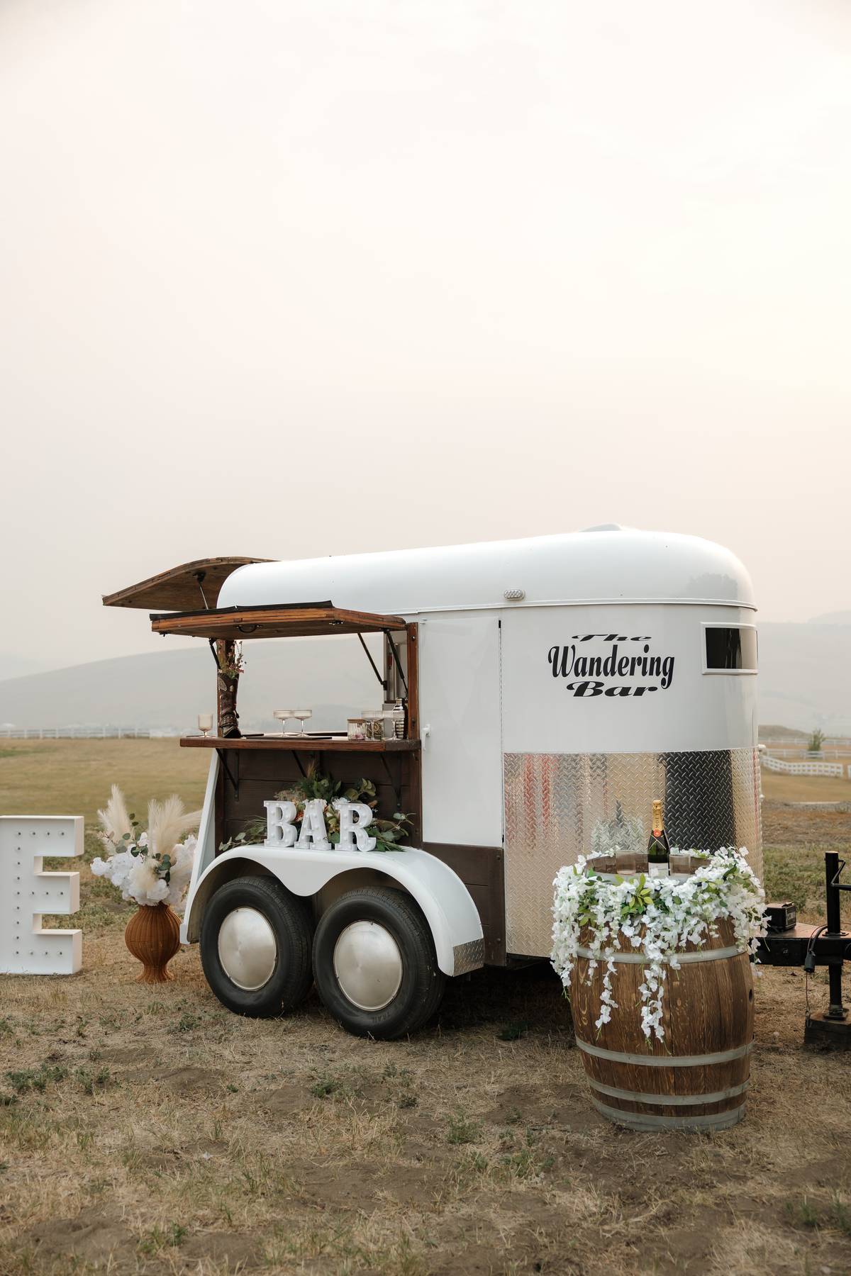 The Wandering Bar trailer exterior with champagne chilling on a barrel$