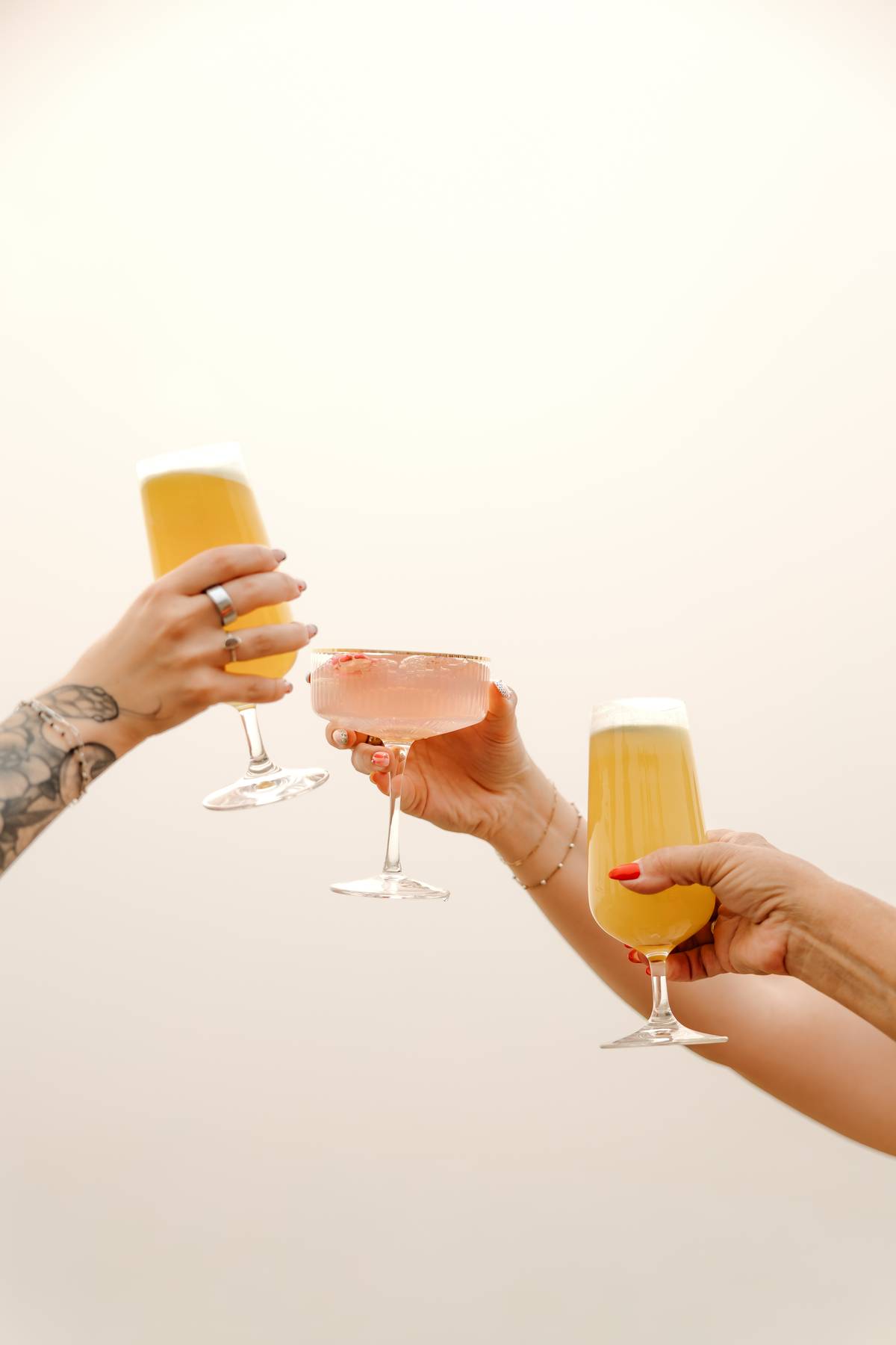 Champagne being poured into a glass held against the sky$
