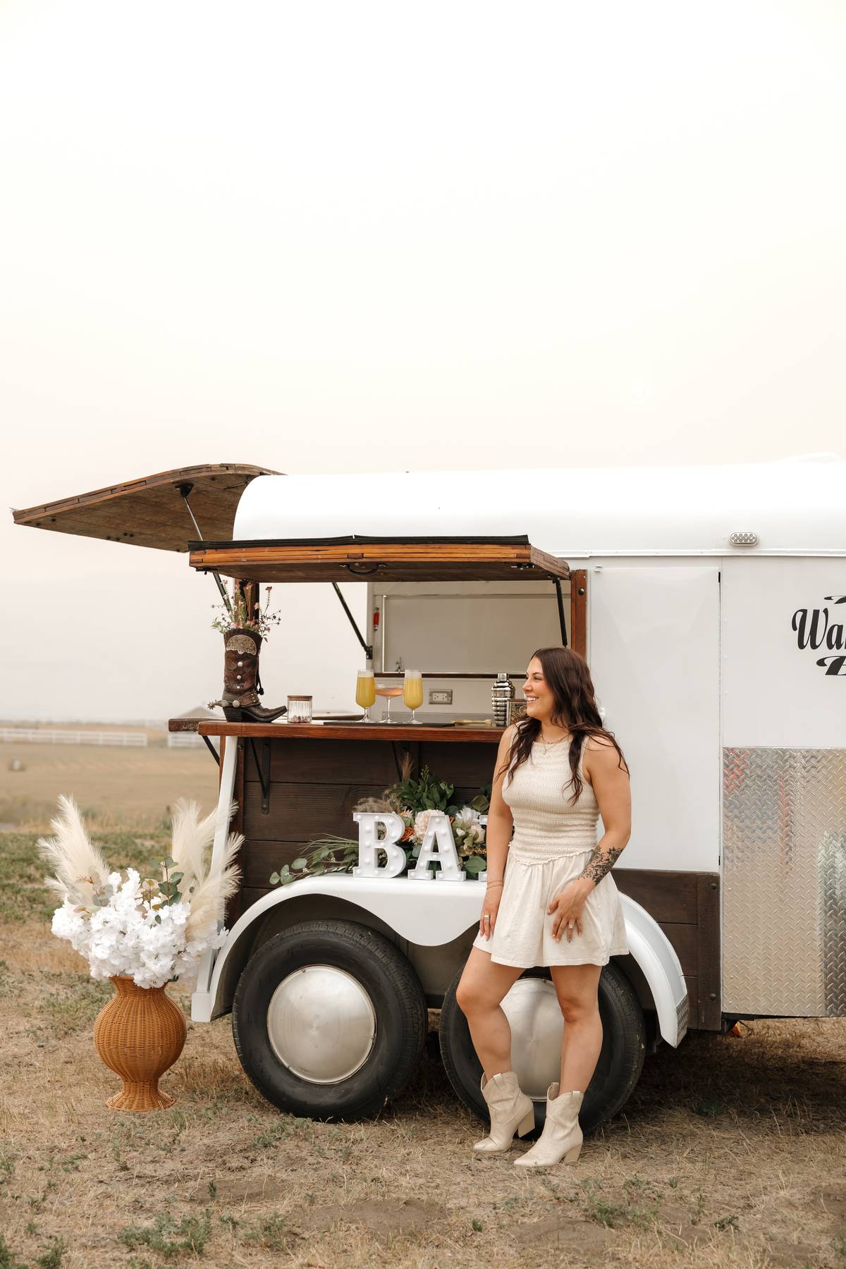 Detail of the trailer bar counter styled with florals and glassware$